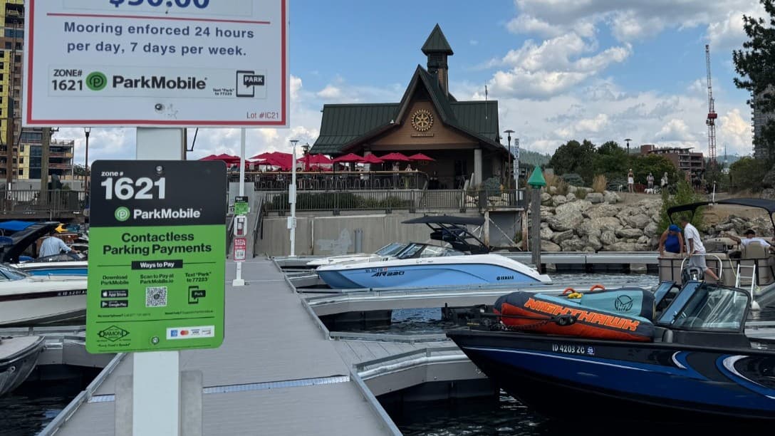 ParkMobile signage on a boat dock for zone 1621 contactless payments, with boats and a marina building in the background.