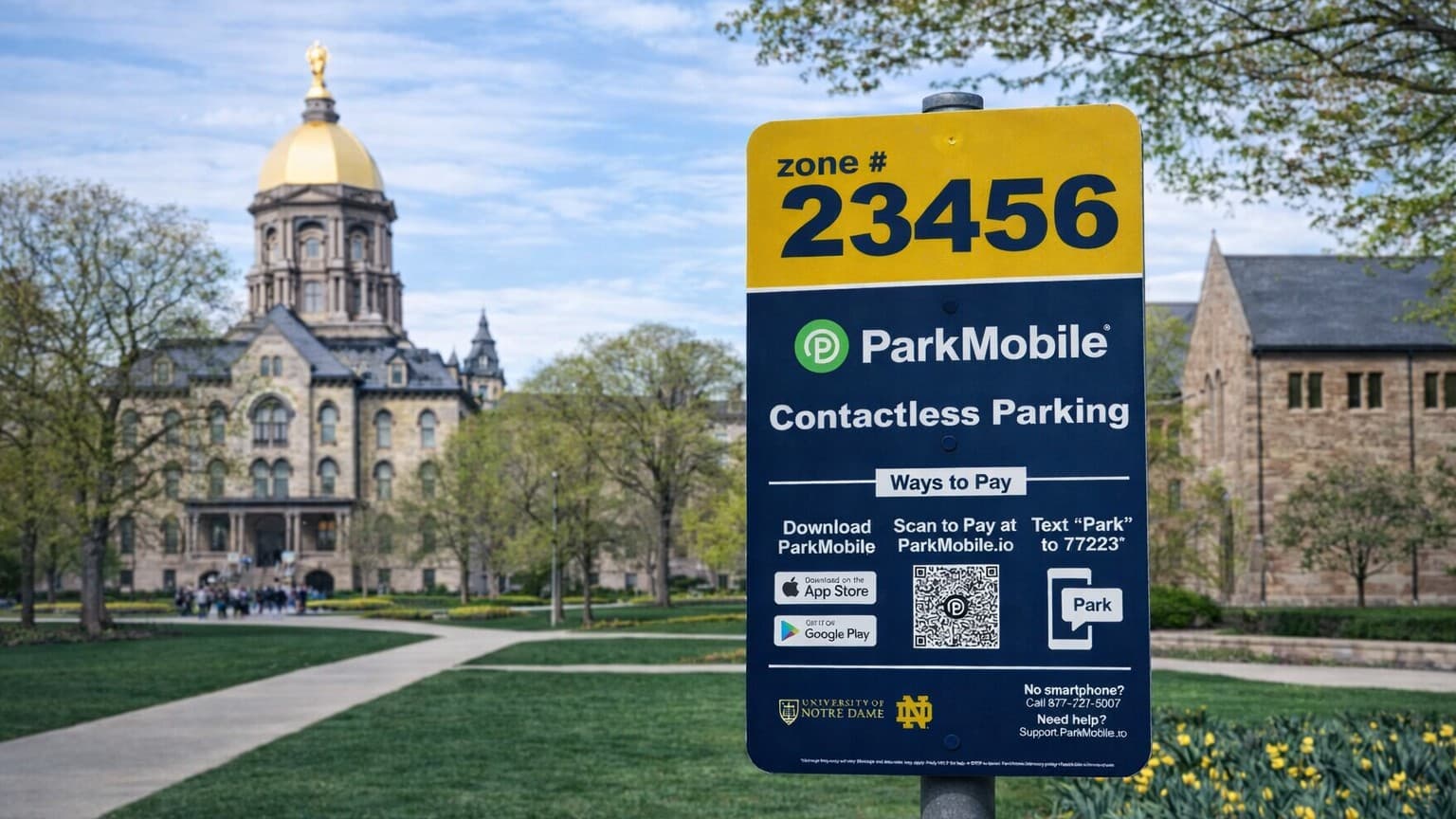 Close-up of a ParkMobile parking zone sign numbered 23456 with the Notre Dame Golden Dome in the background.
