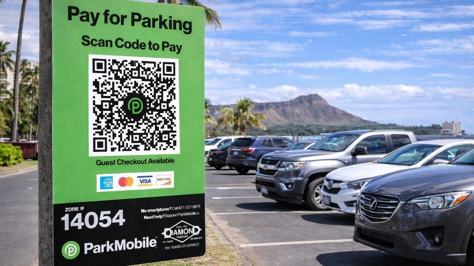 Green ParkMobile parking sign with QR code and zone number 14054, set against a parking lot and Diamond Head mountain.