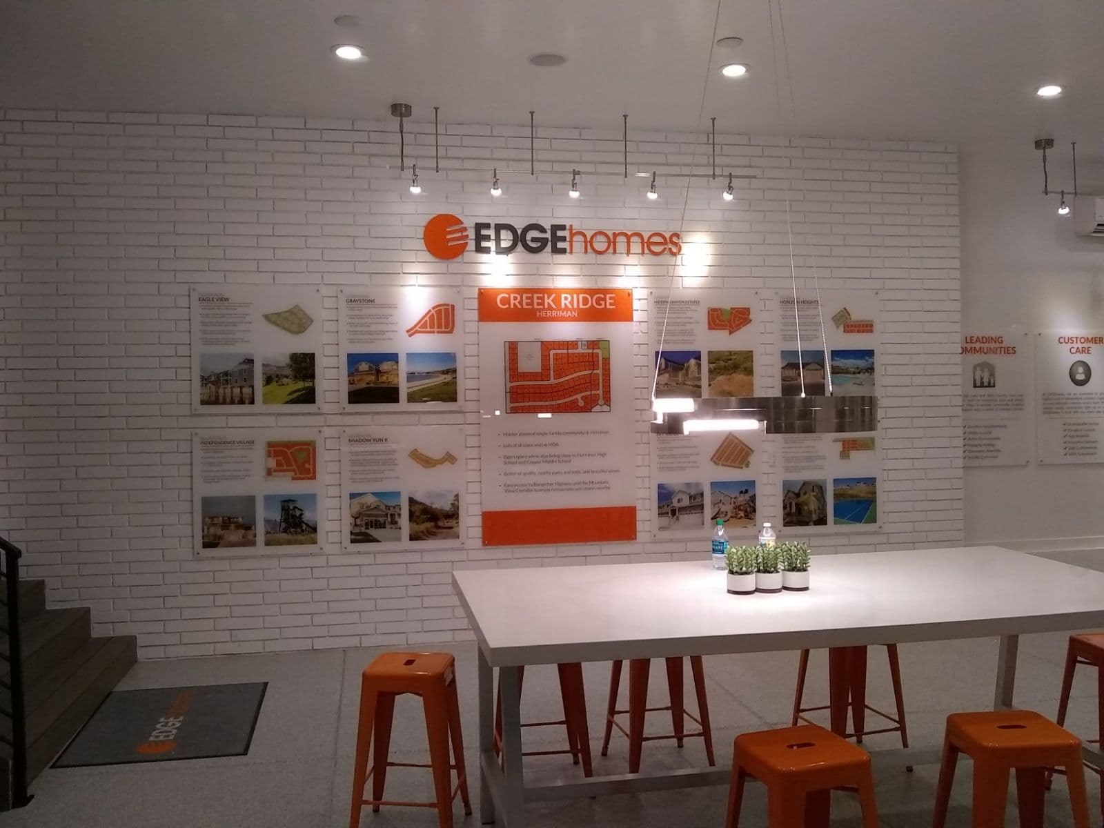 EDGE Homes office interior featuring custom acrylic wall display panels and logo above a conference table.