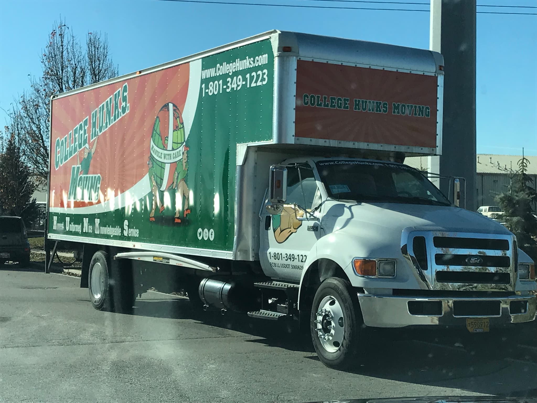 College Hunks Moving box truck featuring custom full body vehicle wrap branding.