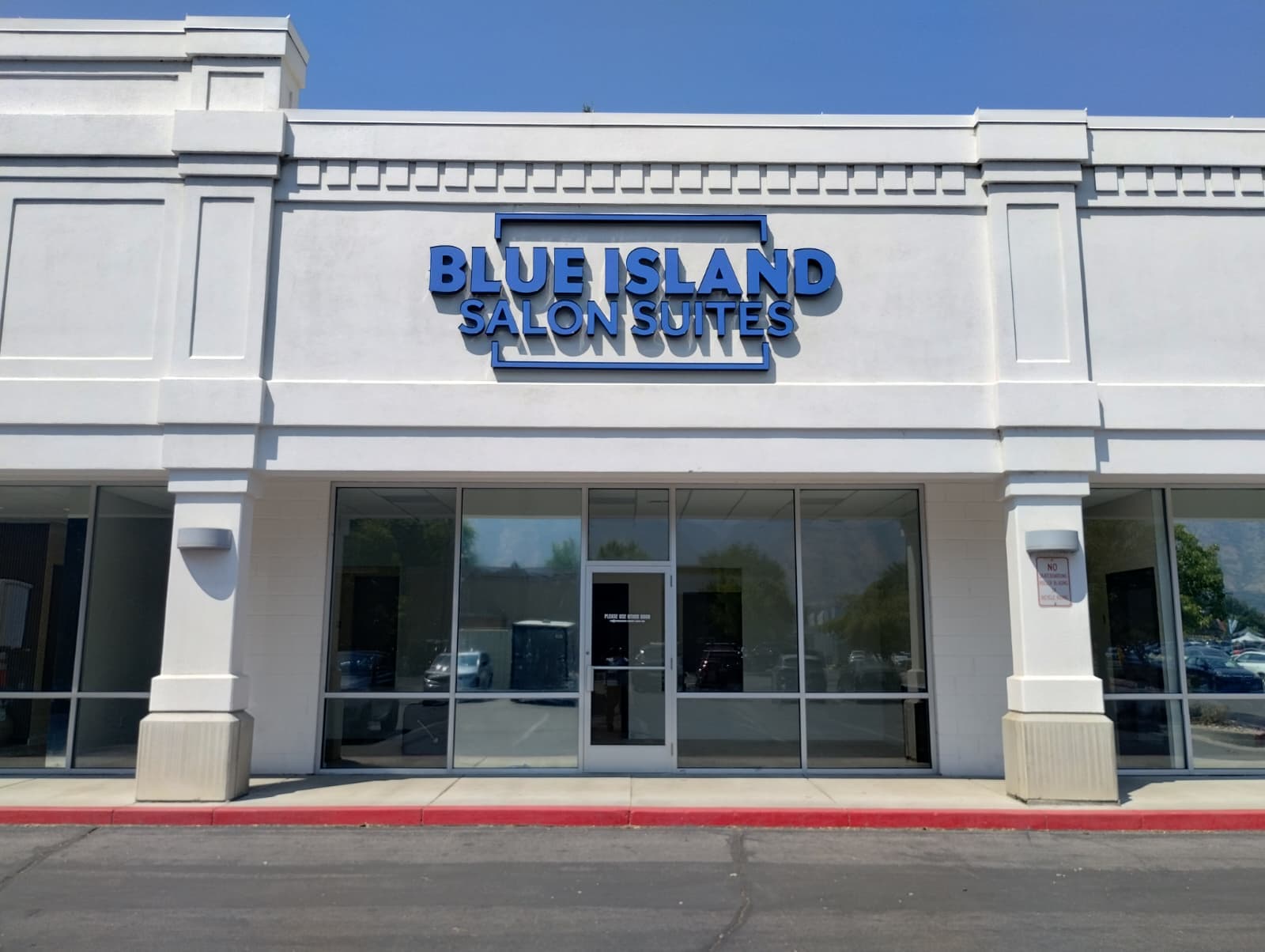 Exterior view of Blue Island Salon Suites featuring blue dimensional letter signage above large glass windows.