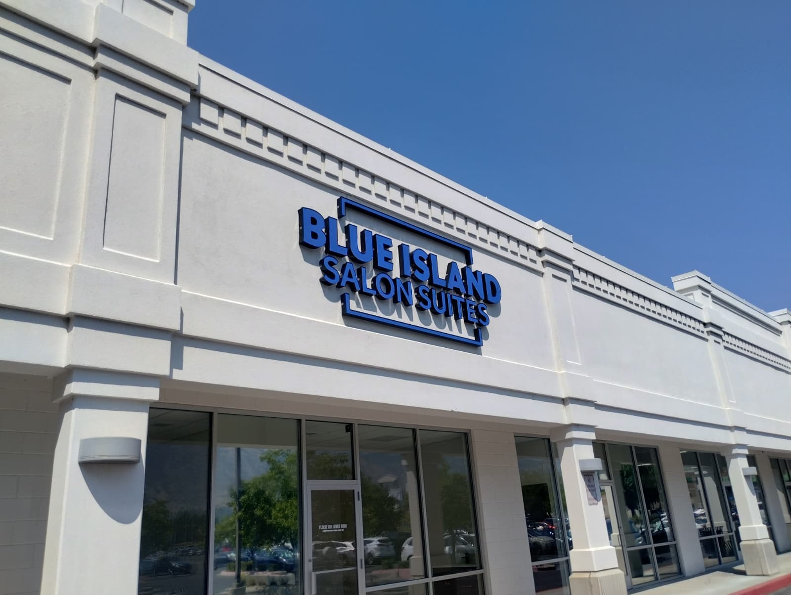 Exterior blue channel letter sign for Blue Island Salon Suites on a white building.