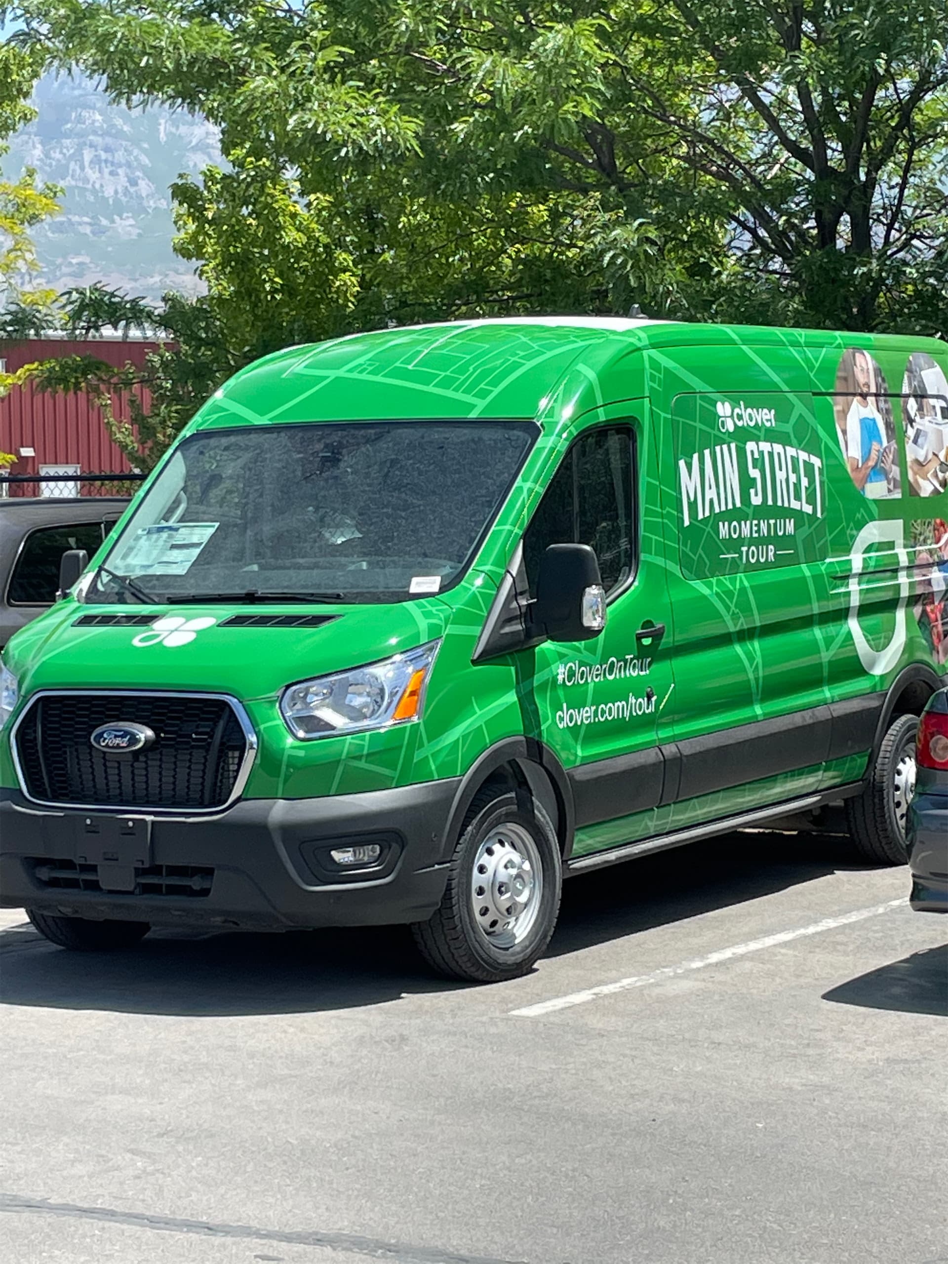 Bright green Ford Transit van fully wrapped with Clover Main Street Momentum Tour graphics.