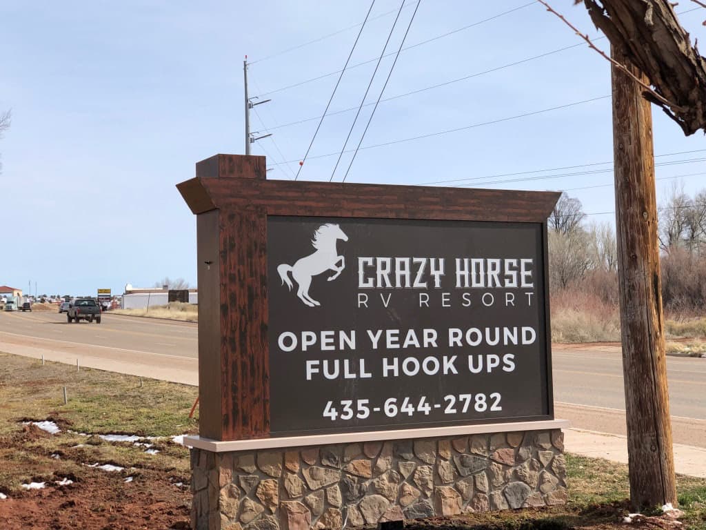 Crazy Horse RV Resort custom outdoor monument sign with stone base and horse logo.