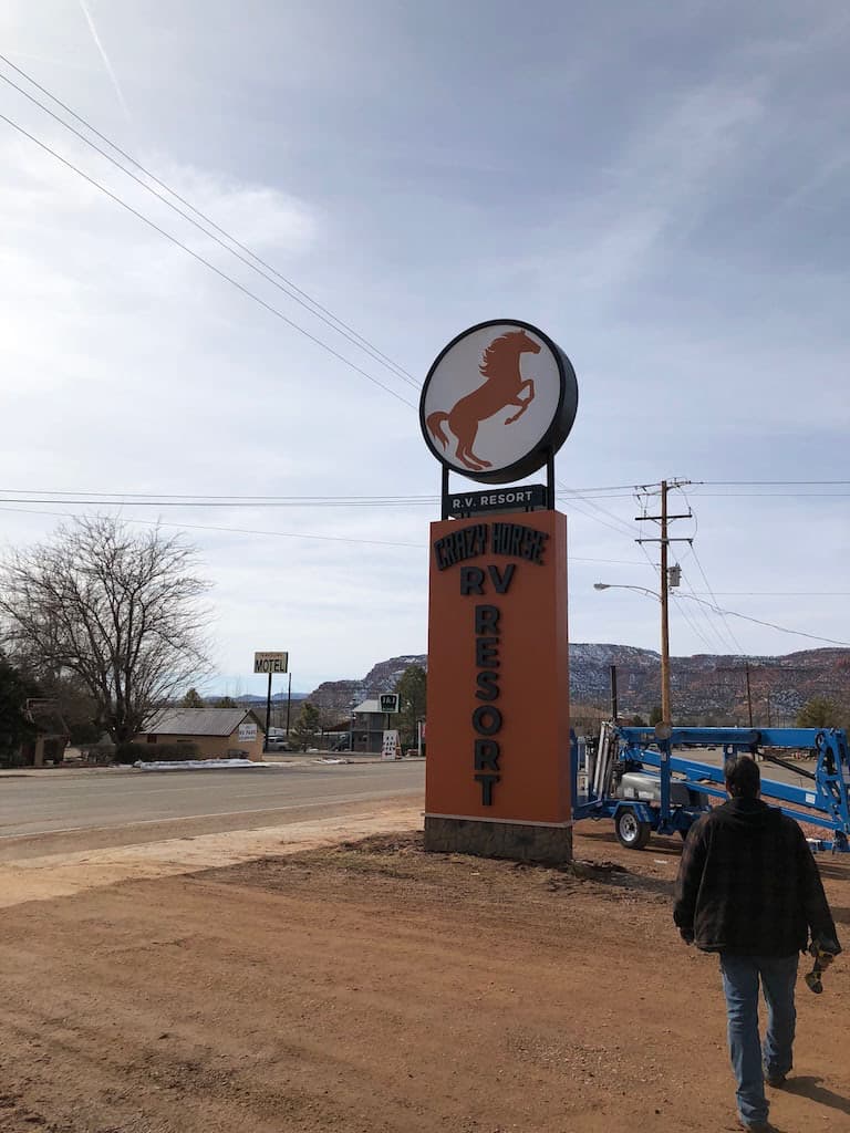 Tall outdoor Crazy Horse RV Resort pylon sign featuring a rearing horse logo on a roadside location.