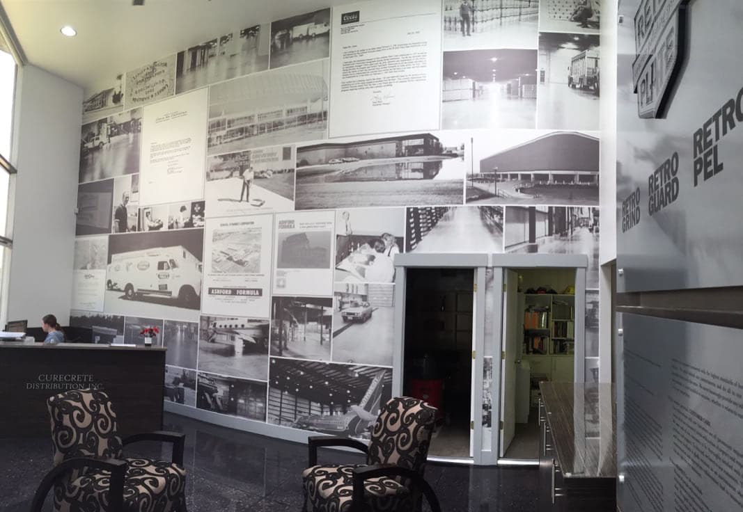 Corporate lobby featuring a large wall mural of historic black and white images at Curecrete Distribution Inc.