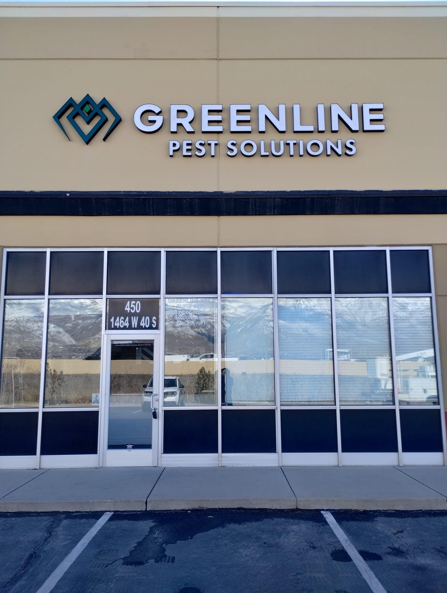Greenline Pest Solutions exterior dimensional building sign above a commercial storefront.