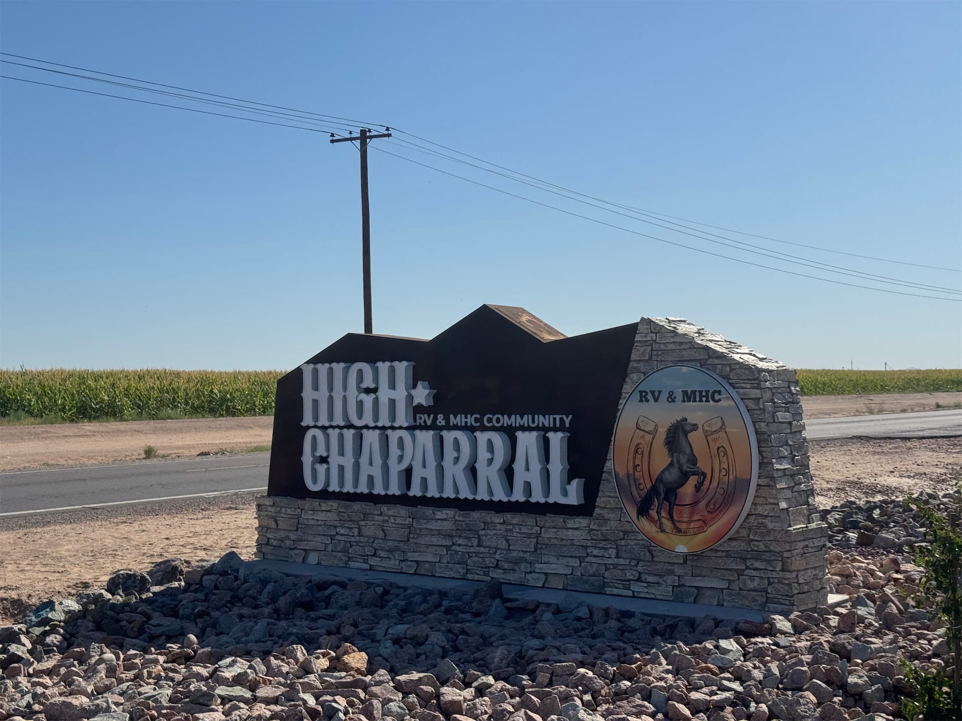 Monument entrance sign for High Chaparral RV & MHC Community featuring stone masonry and horse logo.
