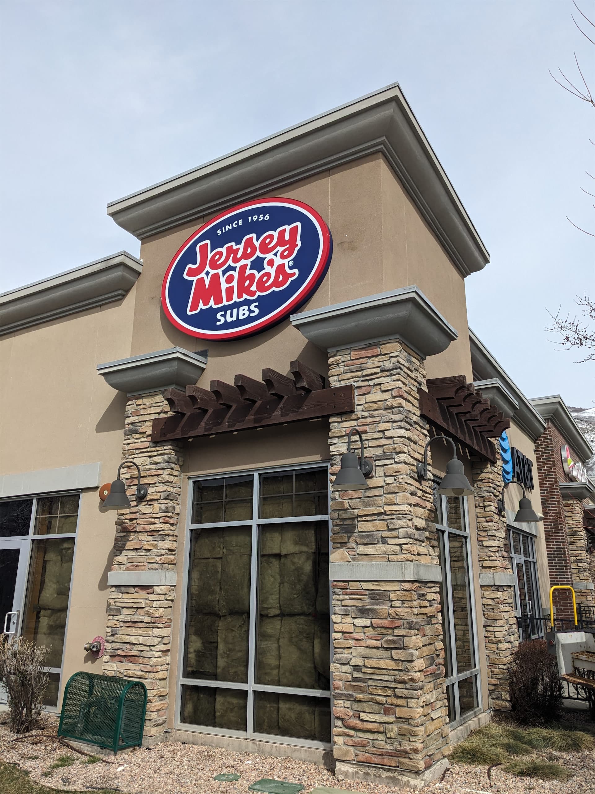 Jersey Mike's Subs exterior storefront building sign mounted on a stone wall.
