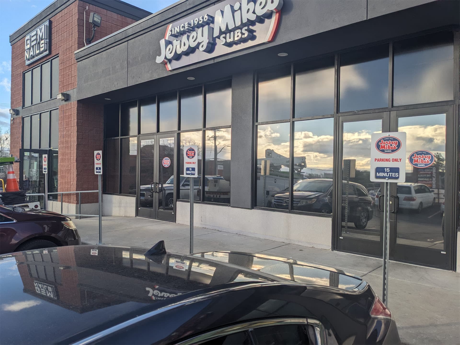 Exterior view of Jersey Mike's Subs storefront with custom building signage and parking signs.