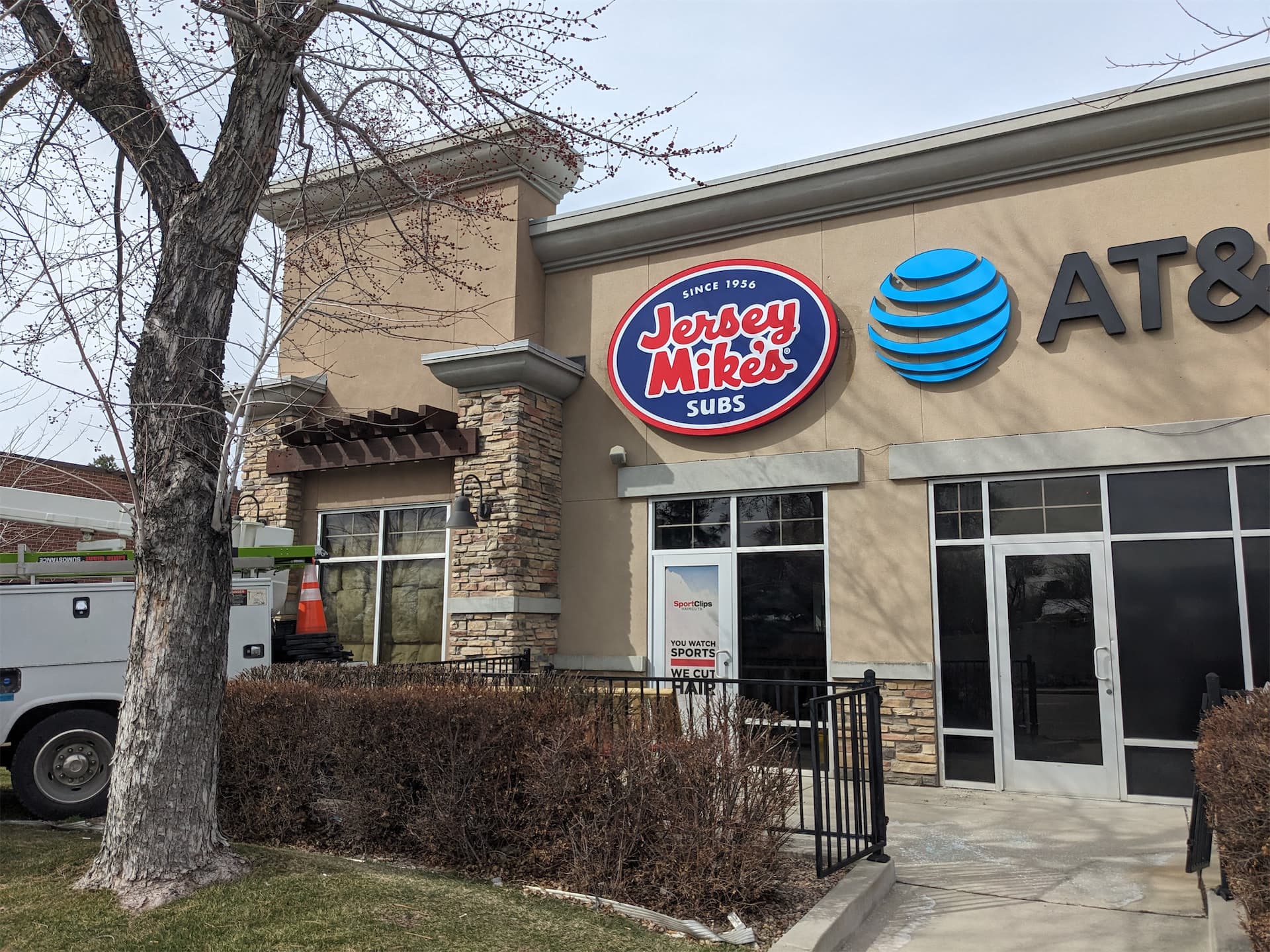 Exterior building signage for Jersey Mike's Subs mounted on a retail storefront next to an AT&T sign.
