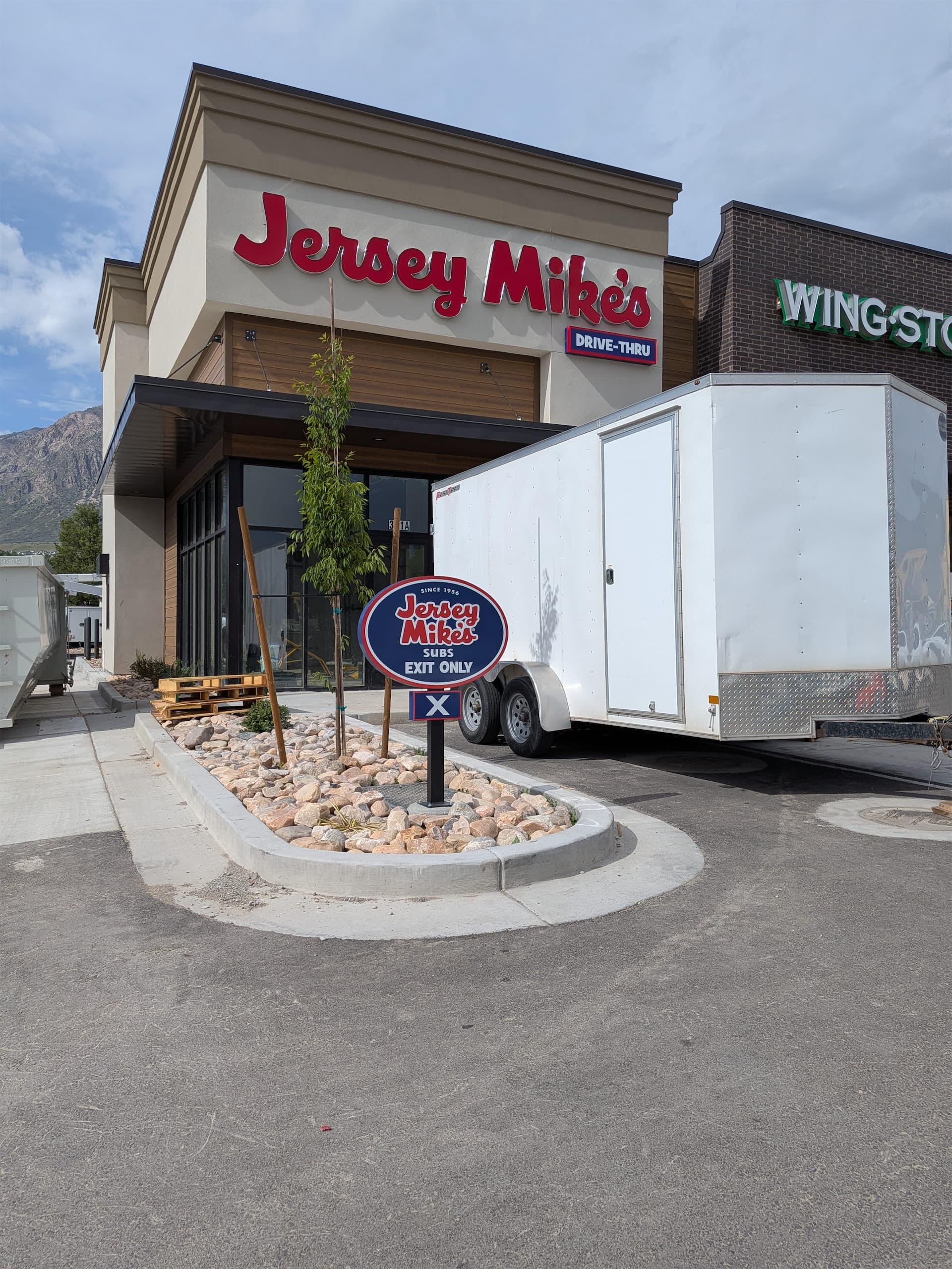 Exterior view of a Jersey Mike's Subs location featuring red channel letter signage and an exit only sign.