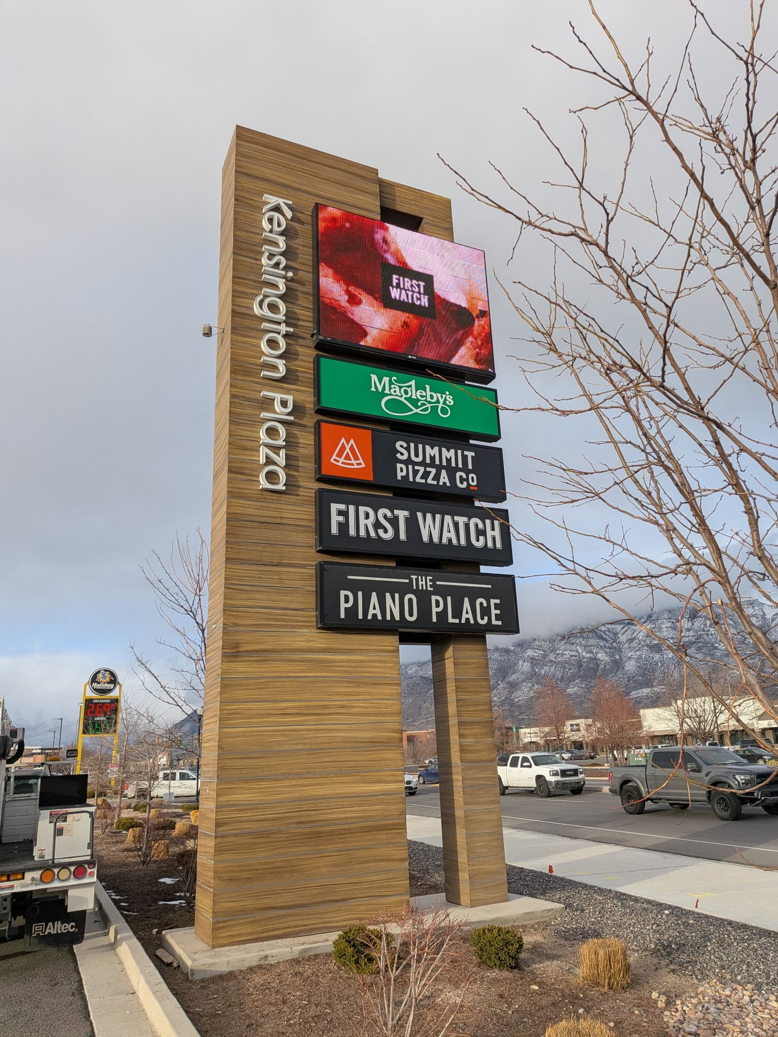Kensington Plaza outdoor pylon sign featuring digital screen display and tenant logos including Summit Pizza Co.