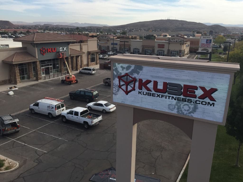 Kubex Fitness monument sign and building storefront signage at a commercial plaza.