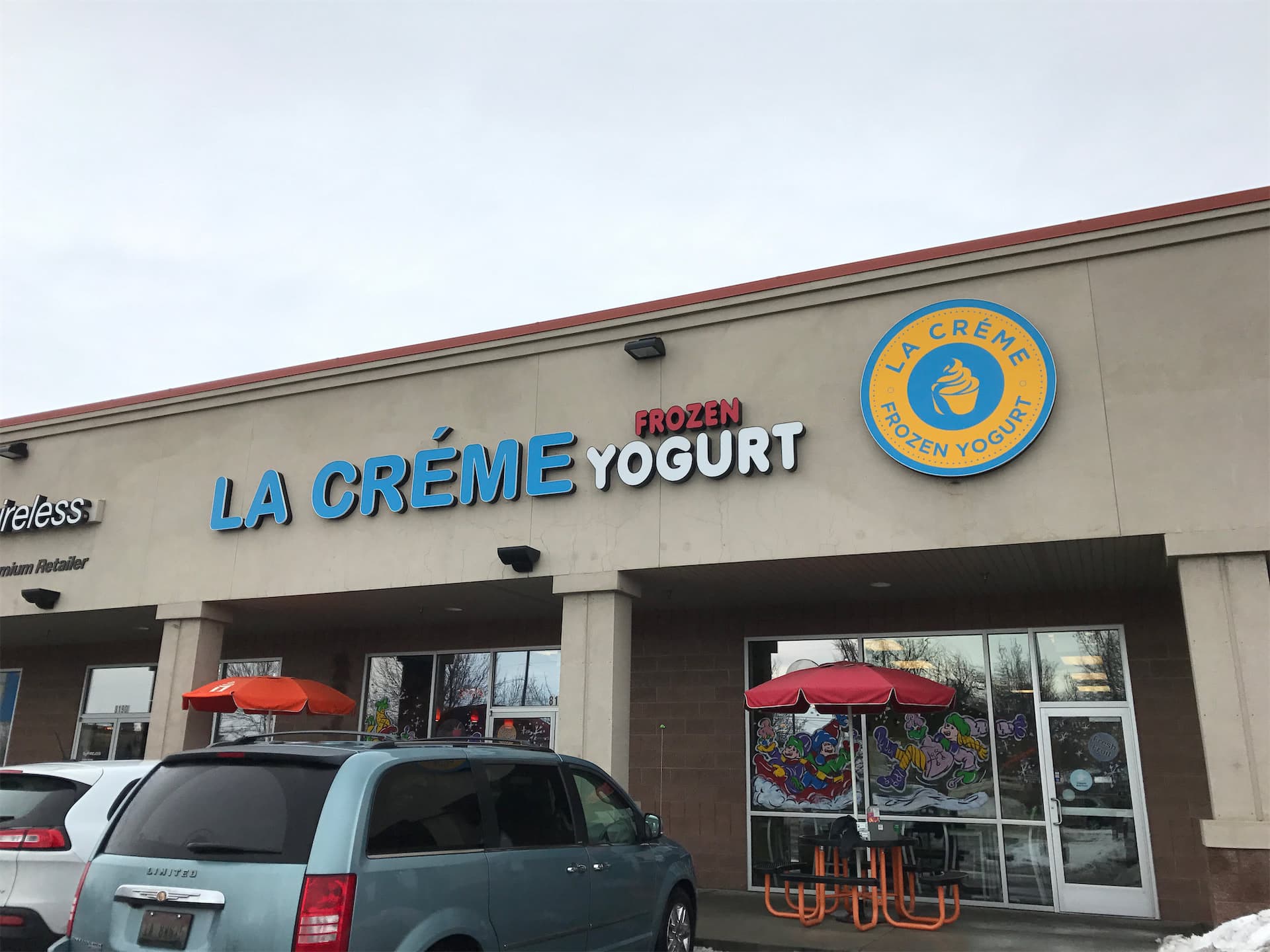 Exterior storefront of La Crème Frozen Yogurt with custom channel letters and a circular logo sign.