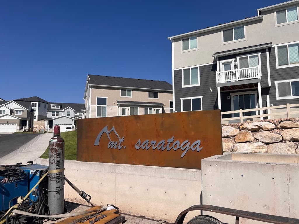 Mt. Saratoga corten steel entry sign installed in front of a modern residential townhouse community.