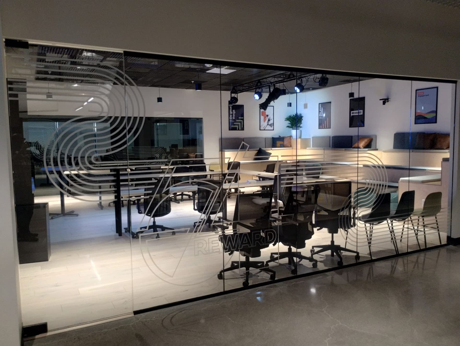 Frosted vinyl decals with geometric designs on a glass wall in a modern office space.