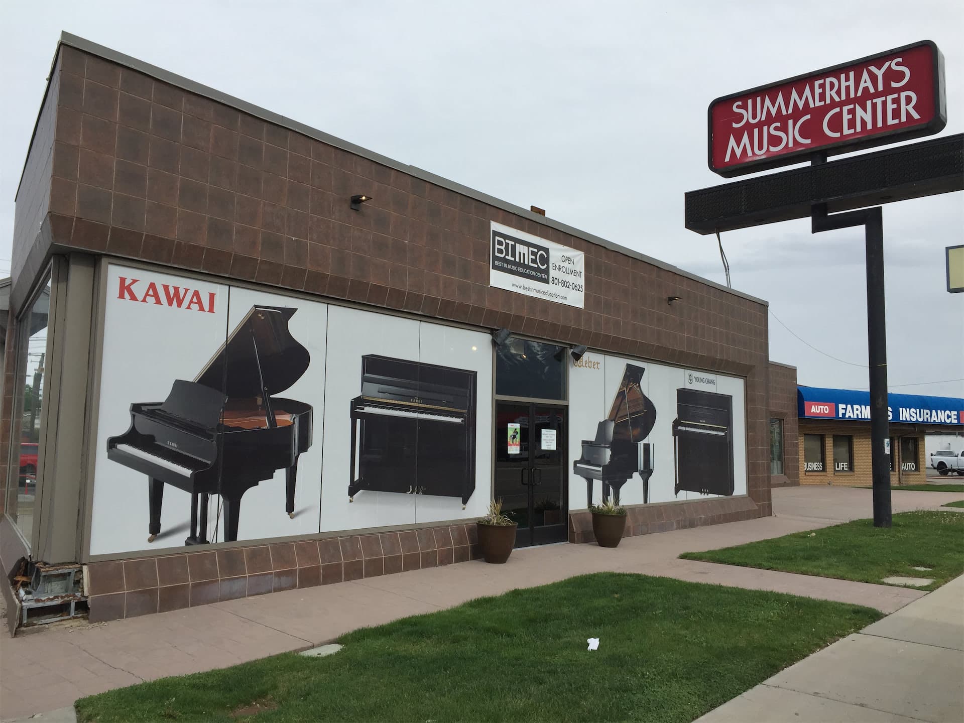 Storefront of Summerhays Music Center featuring large piano vinyl window graphics.