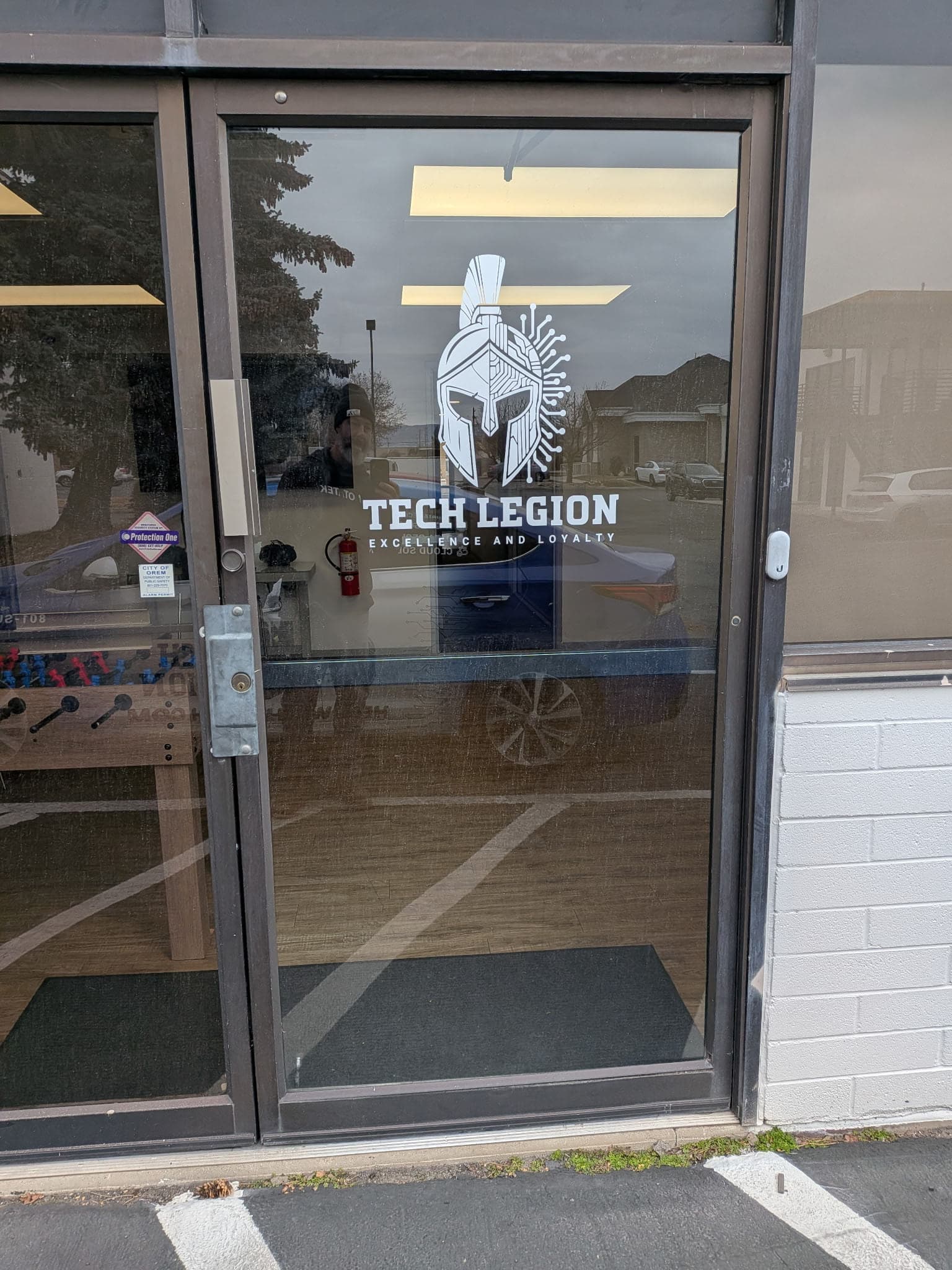 White custom vinyl decal logo on a glass office entrance door for Tech Legion.