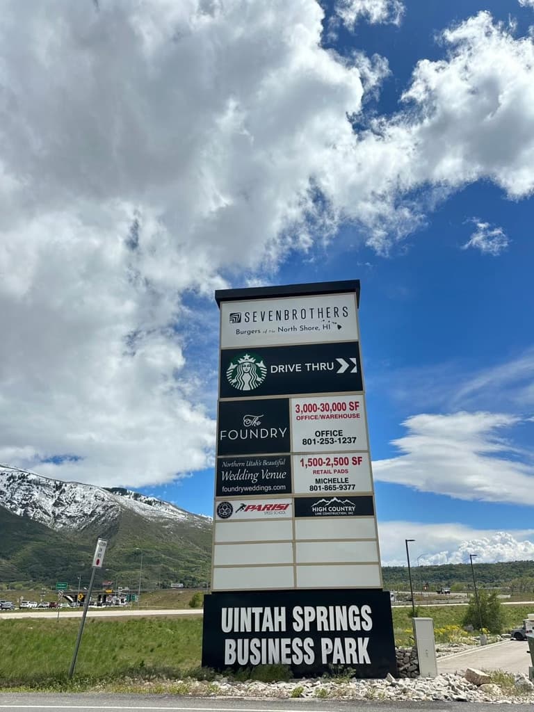 Large Uintah Springs Business Park pylon sign featuring directory panels against a mountain backdrop.