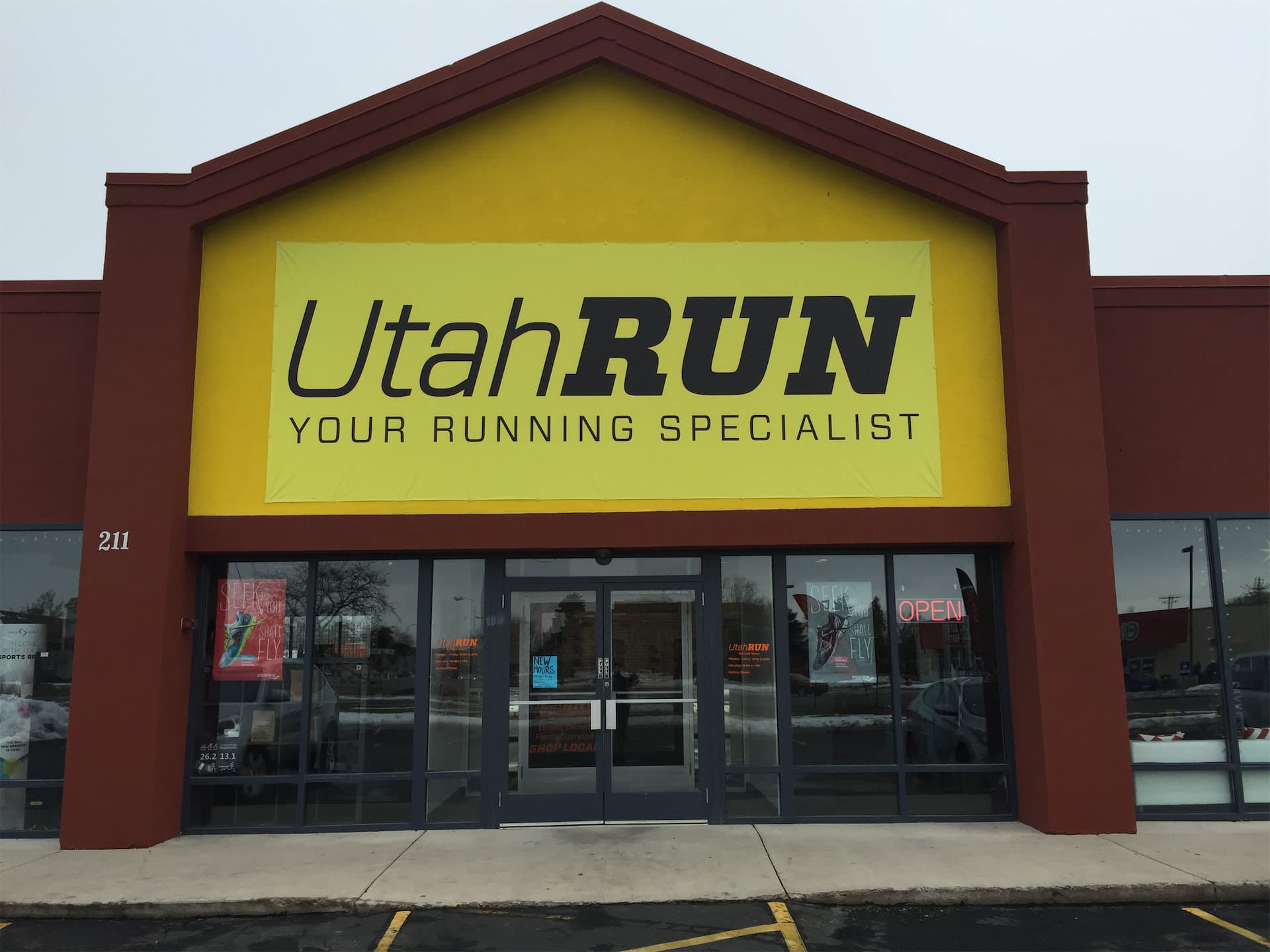 Exterior view of the UtahRUN retail store featuring a bright yellow banner sign above the entrance.