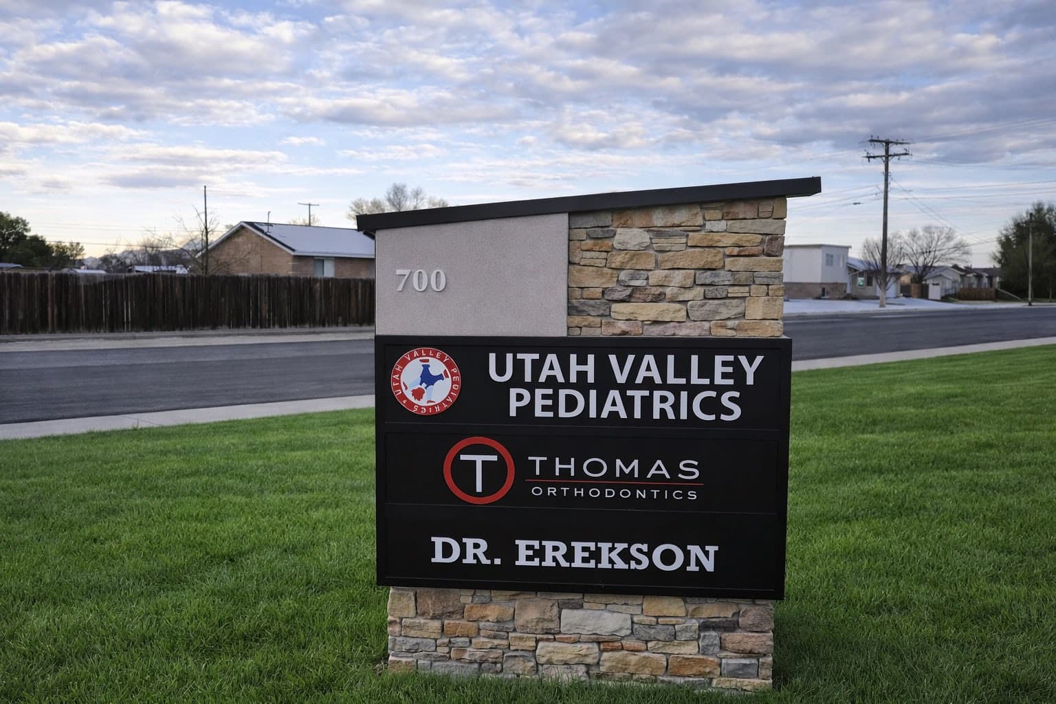 Monument sign for Utah Valley Pediatrics and Thomas Orthodontics surrounded by grass.