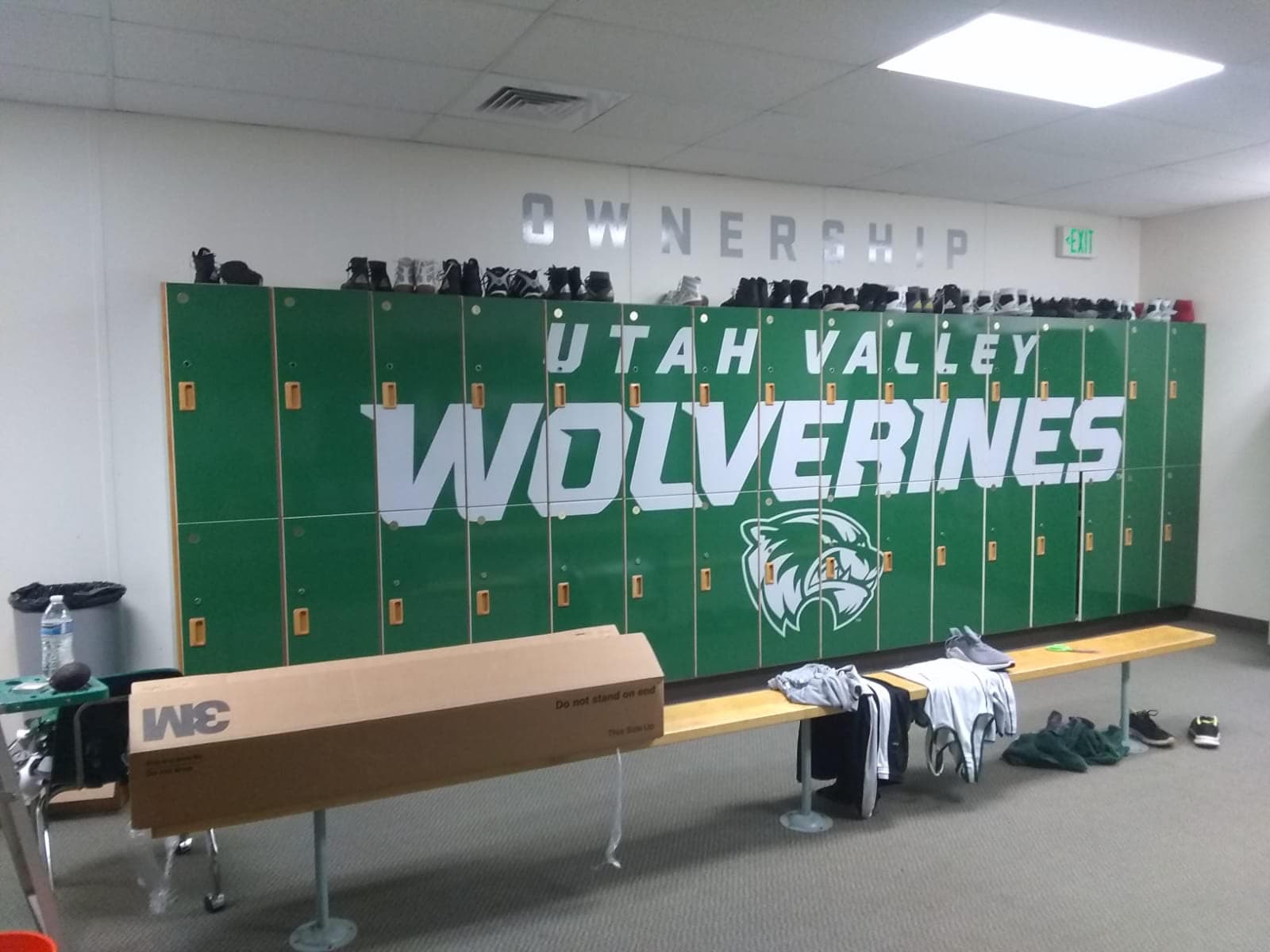 Green locker room lockers featuring Utah Valley Wolverines custom graphic wrap and mascot logo.