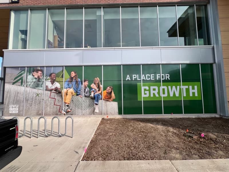 Large Utah Valley University window graphics on a building exterior displaying the text A Place for Growth.