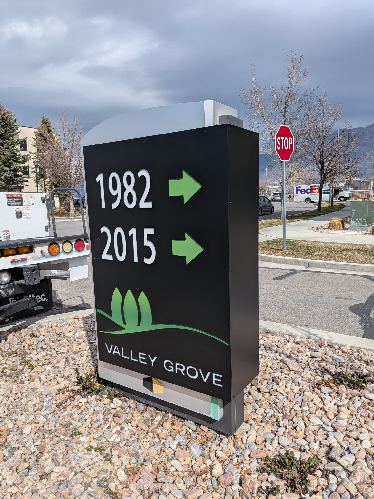 Black Valley Grove outdoor directional monument sign with green arrows pointing toward addresses 1982 and 2015.