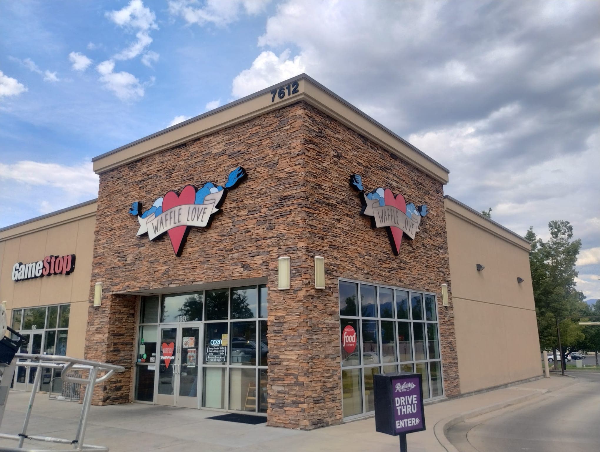 Waffle Love exterior storefront featuring stone facade and mounted heart-shaped logo signs.