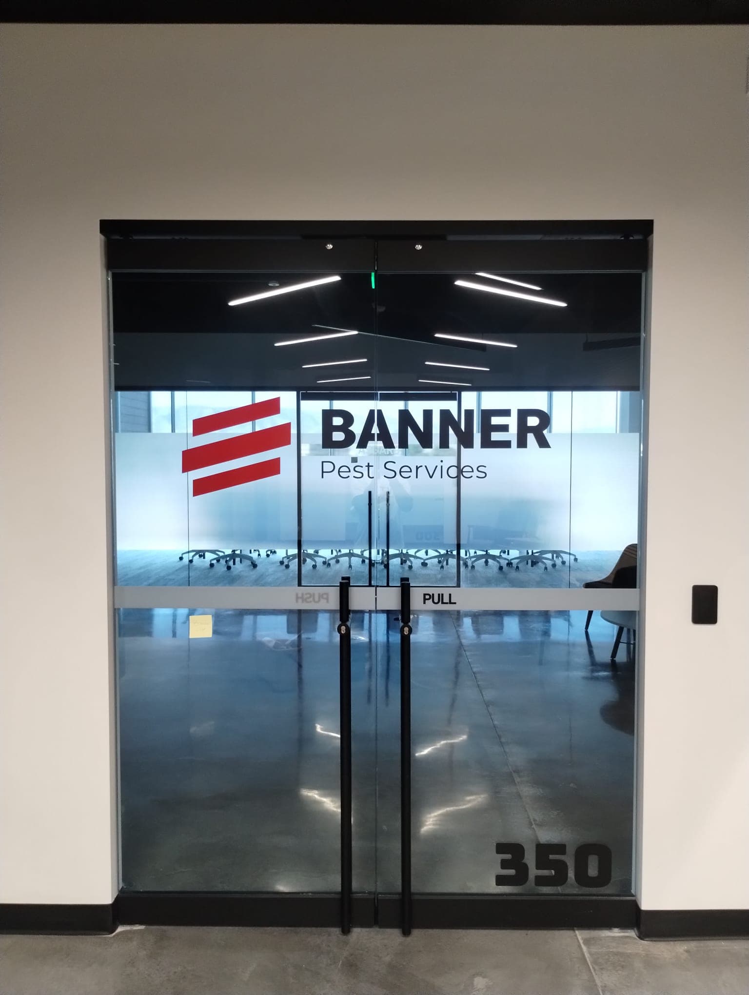 Frosted glass double doors featuring Banner Pest Services logo decals and suite number 350.